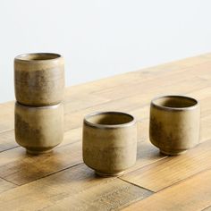 three cups sitting on top of a wooden table