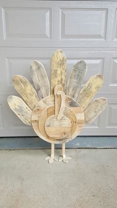 a wooden turkey sitting in front of a garage door