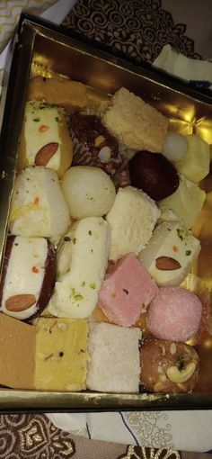 a metal tray filled with different types of food on top of a cloth covered table