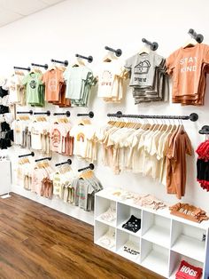 the wall is filled with shirts and t - shirts for children's clothing stores