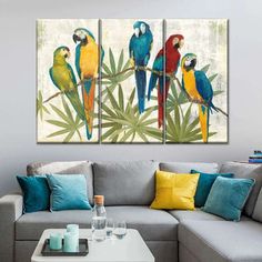 three colorful parrots sitting on a tree branch in front of a white background with blue and yellow accents