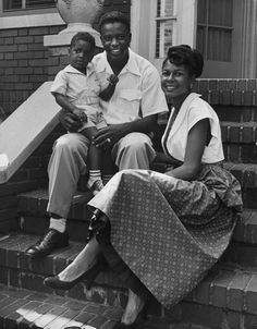 a man and woman sitting on steps with two children