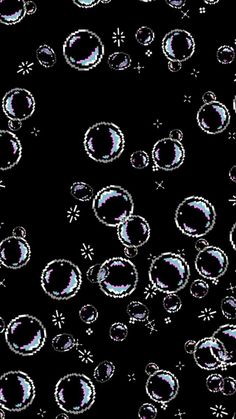 many bubbles are floating in the air on a black background