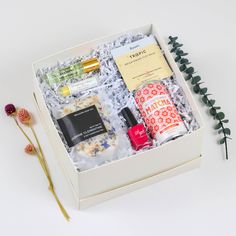 an open box containing cosmetics, perfumes and flowers