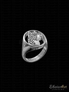 a silver ring with a fish in it's center on a black background,