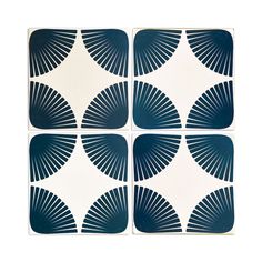 four blue and white square tiles with fan shapes on the bottom, one is made out of