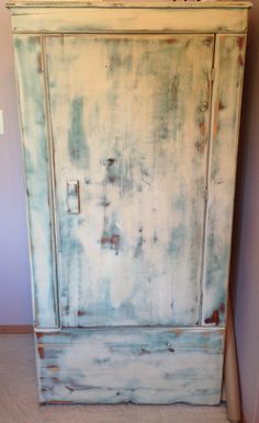 an old white painted armoire in a room