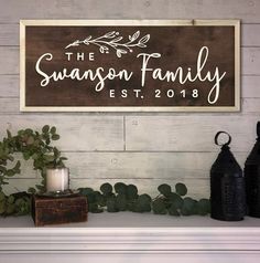 a wooden sign that says the swanson family on it next to candles and plants