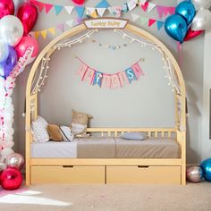 a child's bedroom decorated with balloons, streamers and garlands on the wall