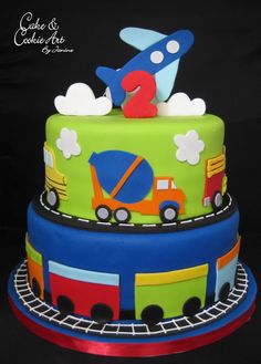 a birthday cake with cars, trucks and planes on it