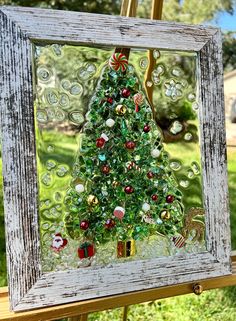 a christmas tree made out of glass sitting on top of a wooden frame