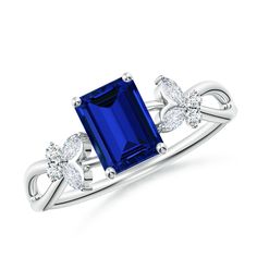 a blue sapphire and diamond ring with two diamonds on the shoulders, set in white gold