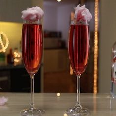 two wine glasses filled with pink liquid sitting on a counter