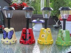 several different colored lights sitting on top of a table next to plants and flowers in vases