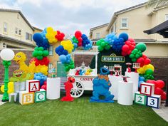 the sesame street ice cream truck is decorated with balloons and streamers for an outdoor birthday party