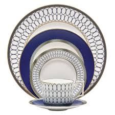 the blue and white dinnerware is set with silver trimmings, which are accented with circles