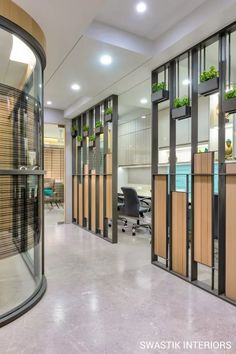 an office with glass partitions and wood accents