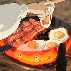 a person cooking eggs and bacon in a frying pan