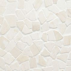 a white stone wall that has been made with different shapes and sizes, including small rocks