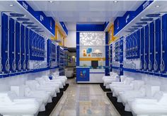 a bathroom with blue and yellow walls, white toilets and sinks in the middle of it