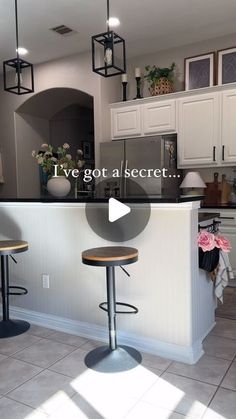 a kitchen with two stools in front of the counter and an open area for seating