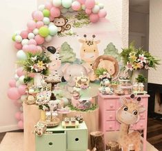 a baby's first birthday party with pink and green decorations, giraffes