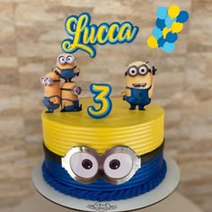 a birthday cake with three minion characters on top and the number 3 in front