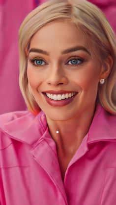 a woman with blonde hair and blue eyes wearing a pink shirt smiles at the camera