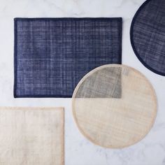 three rugs and two place mats on a marble surface