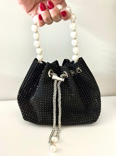 Length: 5.91 inches, Height: 5.71 inches This beautiful black bag is perfect for fancy dinner, date nights or as a gift to a friend. It can be carried as a hand bag or a crossbody. It comes with a detachable chain strap. The pearl handle and rhinestone studs make this a statement bag  evening pearl bag evening bag sequin evening bag evening clutch purse black clutch  evening bag black purse black bag evening stylish clutch affordable holiday gift black rhinestone bag  black rhinestone purse wedding purse bridal bag  bridesmaid purse Luxury Versatile Evening Bag With Detachable Strap, Elegant Bucket Bag With Rhinestones, Elegant Rhinestone Bucket Bag, Elegant Bucket Bag For Events, Black Rectangular Bucket Bag For Party, Formal Bucket Shoulder Bag With Pearl Handle, Evening Bucket Bag With Rhinestones, Evening Bucket Bags With Rhinestones, Elegant Bucket Evening Bag