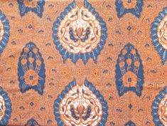 an orange, blue and white paisley pattern on fabric