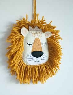 a lion head hanging on the wall with fringes around it's eyes and nose