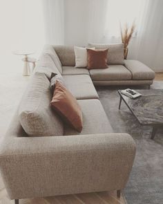 a living room with couches and coffee table in front of a window on the floor