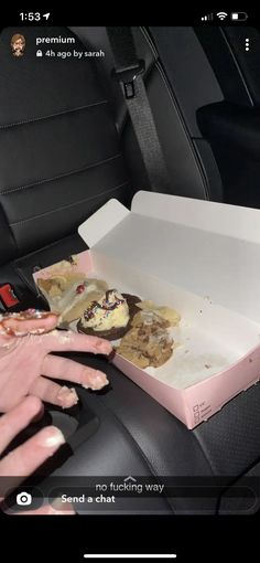 someone is eating pizza in the back seat of a car with their hands on it