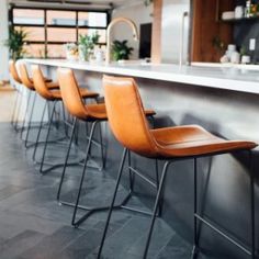 a row of bar stools sitting in front of a counter