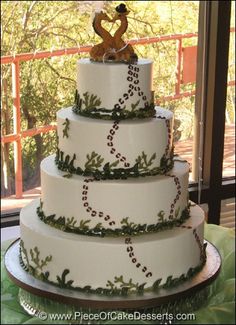 a three tiered wedding cake decorated with holly and an acrylic figure on top