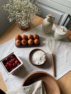 the table is set with eggs, flour and strawberries