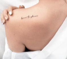 a woman's back with the words born to shine written on it