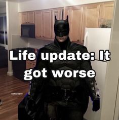 a man dressed as batman standing in front of a refrigerator with the caption life update it got worse