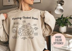 This Nursing Student Brain  Crewneck Sweatshirt is the perfect birthday gift, graduation gift, or Christmas gift for all Nursing Student! All of our shirts are made with the highest quality materials and are super soft and cozy! 💚 HOW TO ORDER 💚 1. Check our photos for sizing and color options. 📏 2. Choose your quantity.  Feel free to add as many shirts as you wish! ✨ 3. Select your size and color from the drop-down menus. ✨ 4. Click "ADD TO CART" to add the shirt to your virtual cart. 🛒 5. Click "PROCEED TO CHECKOUT" to purchase your shirt. 🛒 6. Your shirt is now off to production!  We will process your order and your shirt will be ready for shipment in 1-4 days! 🎁 📏 SHIRT SIZING All of our shirts come in a variety of colors and many different sizes! ✨ SHIRT INFORMATION + MATERIAL Casual Crew Neck Top For Graduation Gift, Casual Crew Neck T-shirt For Graduation Gift, Brain Shirt, Nurse Sweater, Nurse Student, Nurse Graduation Gift, Gift For Nurse, Nursing Graduation, Nursing Student