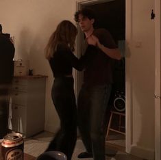 a man and woman dancing in the living room