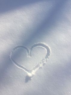 a heart drawn in the snow on a sunny day