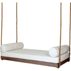 a bed with two pillows on it and some ropes hanging from the ceiling over it