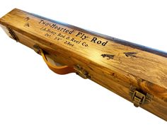 a wooden case with writing on the side and an arrow at the bottom that says, world heritage fly rod