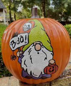 a painted pumpkin with an image of a gnome holding a sign