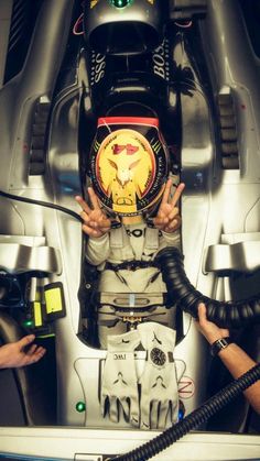 a man sitting in the cockpit of a race car with his hands on the steering wheel