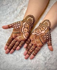 two hands with henna tattoos on them