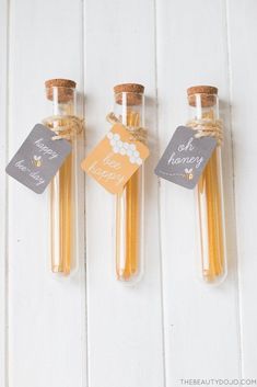 three small bottles filled with honey sitting next to each other