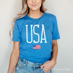 a woman wearing a blue usa t - shirt with the american flag on her chest