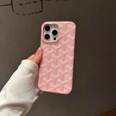 a person holding up a pink phone case